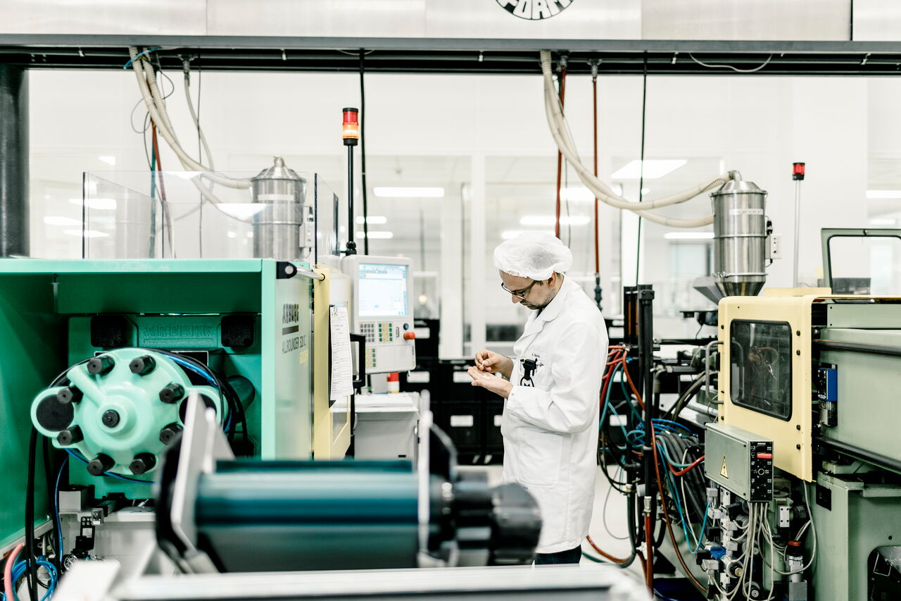 Ein IMF-Mitarbeiter prüft in der Produktion ein Produkt